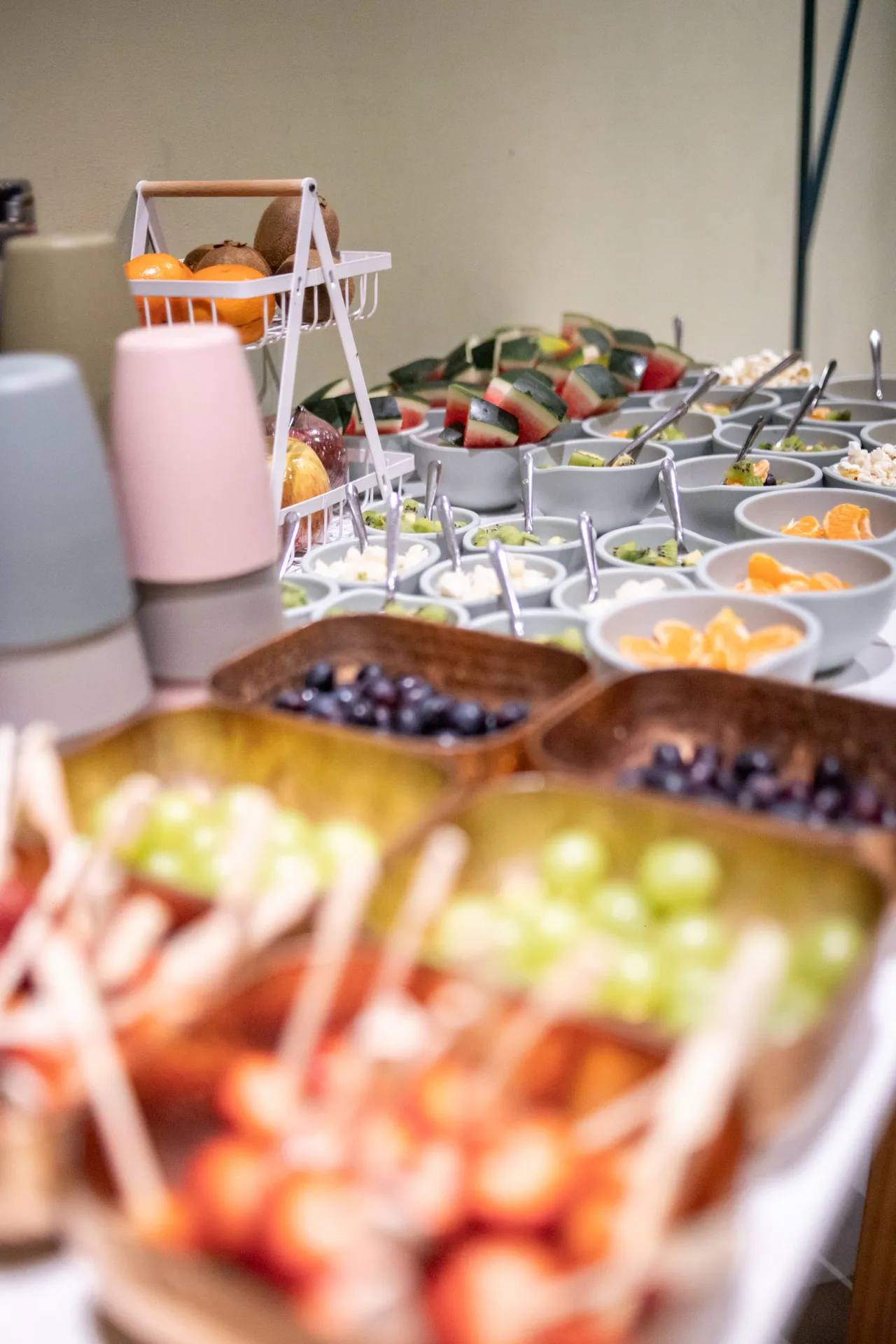 Buffet com bowls de frutas frescas e salgados servidos na festa